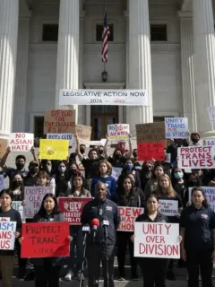 Activists advocating for stronger hate crime legislation in 2026, holding signs and banners.