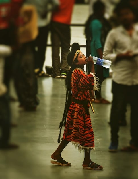 A group of people performing a traditional dance from their native country at a cultural festival in an American city. The performers are wearing vibrant costumes, and the audience is a mix of people from different backgrounds, all enjoying the cultural performance.