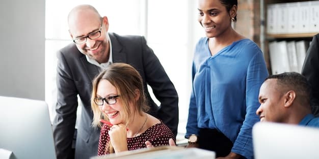 A diverse group of employees working together in a brightly lit office, symbolizing a focus on human capital management.