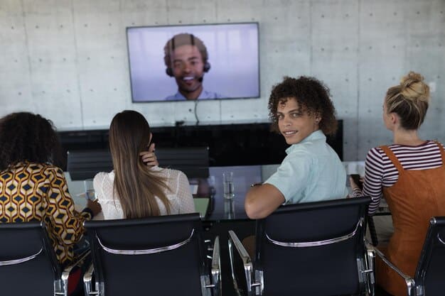A diverse group of employees participating in an interactive ethics training workshop, with a facilitator guiding the discussion. The setting is a modern conference room.