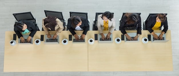 Top-down view of a diverse team of employees collaborating on writing a code of ethics, with laptops displaying draft documents and annotation tools.