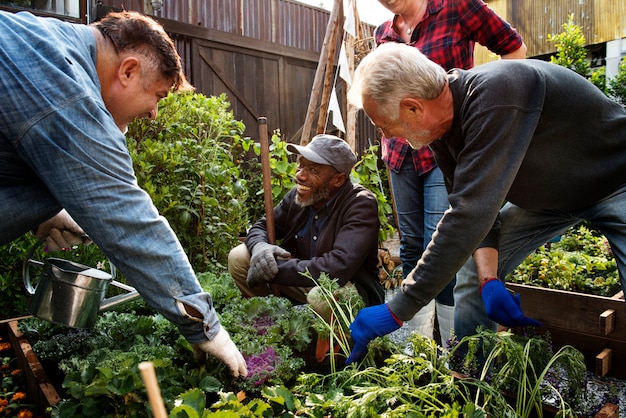 A group of volunteers working together in a community garden, planting vegetables and flowers. They are of diverse ages and ethnicities, and their faces show a sense of purpose and collaboration. Tools and gardening supplies are visible in the background.